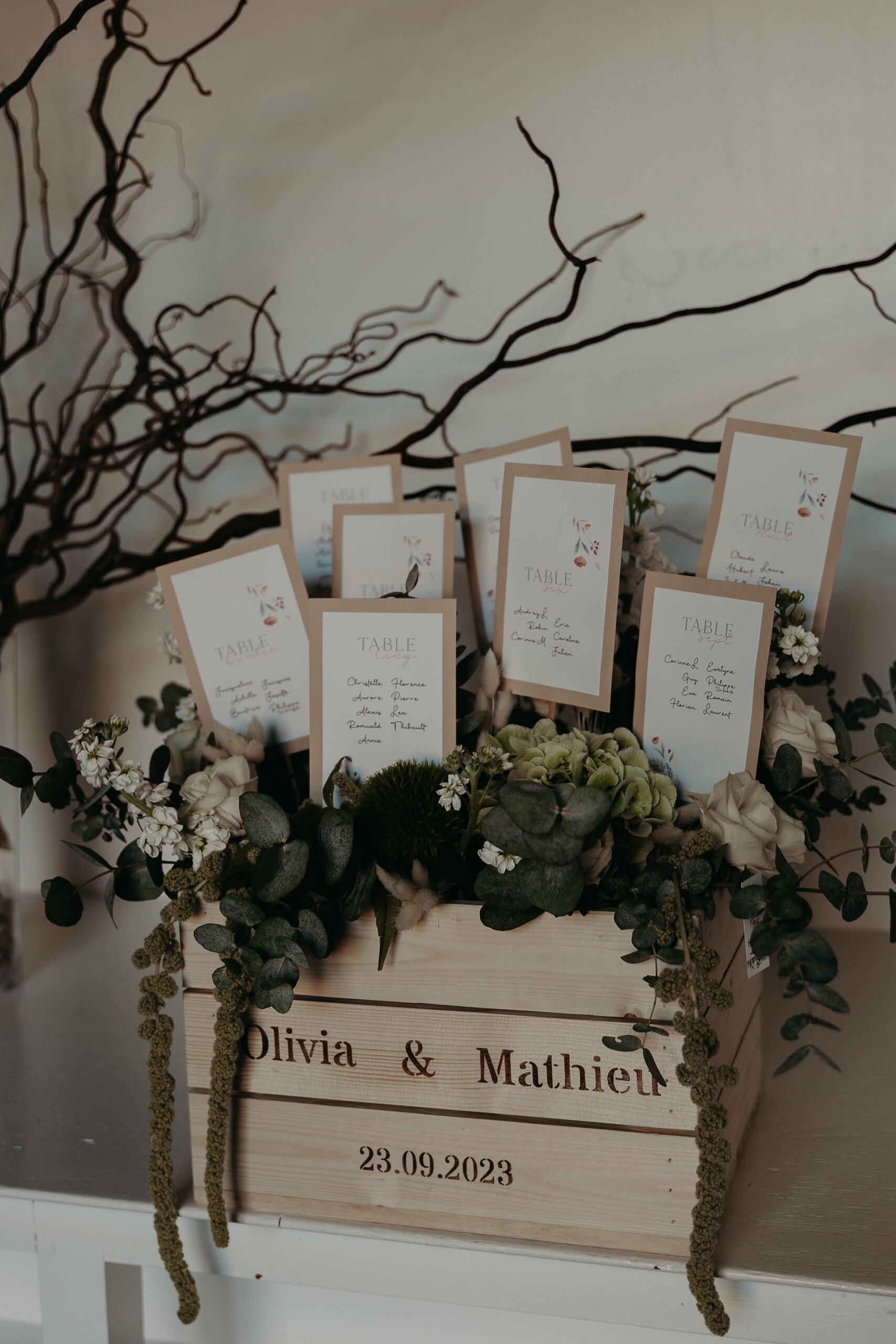 Plan de table réalisé sur le thème de la nature, avec des cartes personnalisées, plantées dans une composition florale.